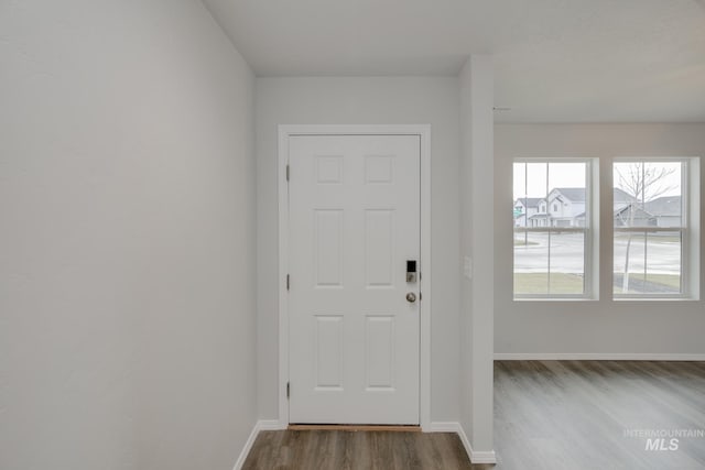 doorway featuring dark wood-style floors and baseboards