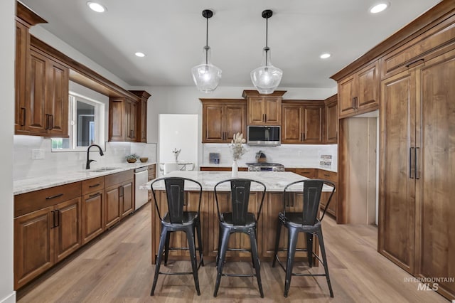 3675 E 3711 N, Kimberly, ID 83341 - kitchen with appliances with stainless steel finishes, a sink, backsplash, a kitchen island, and light wood-style floors
