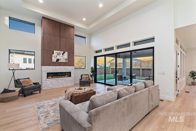 9891 W Napier Ct, Star, ID 83669 - living room featuring recessed lighting, a large fireplace, light wood finished floors, and a towering ceiling