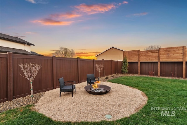 9891 W Napier Ct, Star, ID 83669 - yard at dusk with a fenced backyard, a fire pit, and a patio area