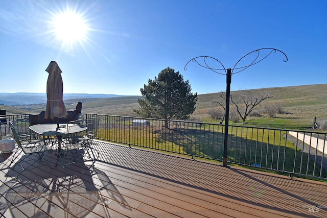 wooden terrace featuring outdoor dining space and a mountain view