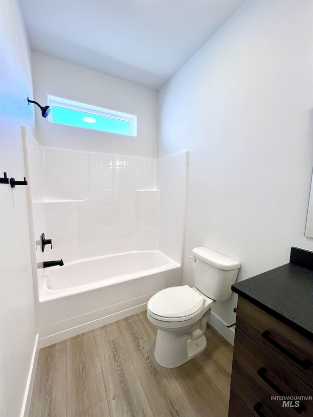 full bathroom featuring shower / bathtub combination, toilet, wood finished floors, vanity, and baseboards