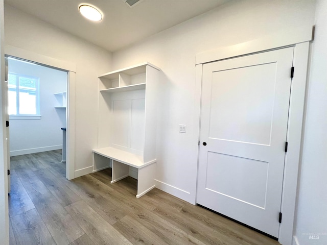 mudroom featuring wood finished floors and baseboards