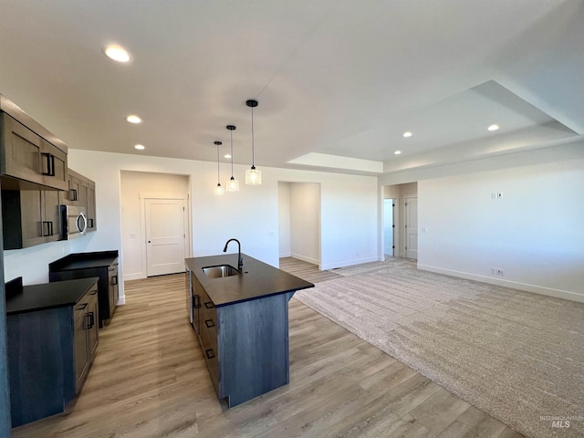 kitchen with dark countertops, a sink, and recessed lighting