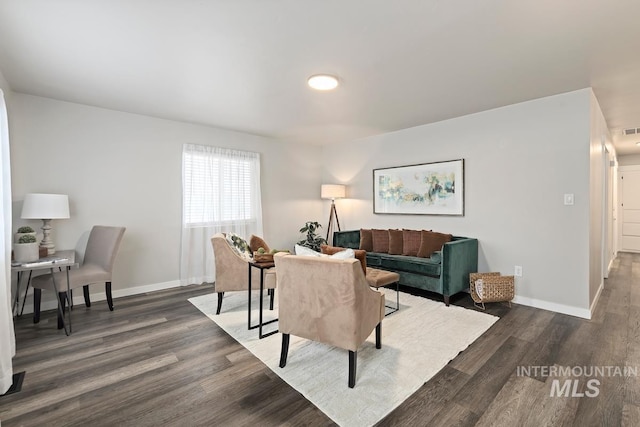 living area with dark wood finished floors, visible vents, and baseboards