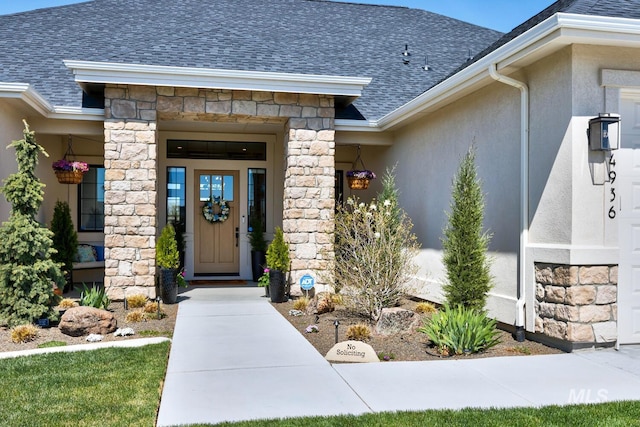 property entrance with a shingled roof, stucco siding, and stone siding