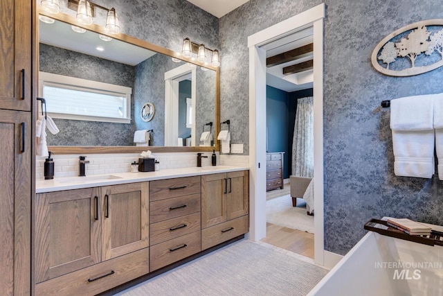 bathroom featuring decorative backsplash, double vanity, and a sink
