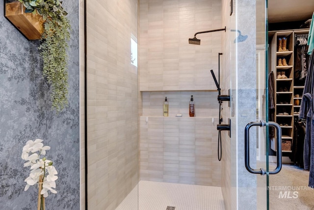 bathroom with a stall shower and a walk in closet