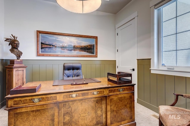 office space with light colored carpet, a wealth of natural light, and a wainscoted wall