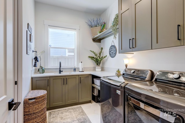 clothes washing area with light tile patterned floors, a sink, cabinet space, and washing machine and dryer
