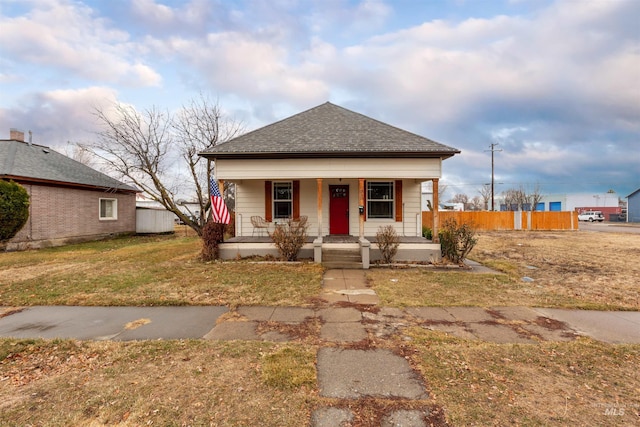 bungalow-style house featuring covered porch and a front lawn