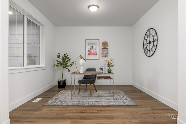 office space featuring visible vents, baseboards, and wood finished floors