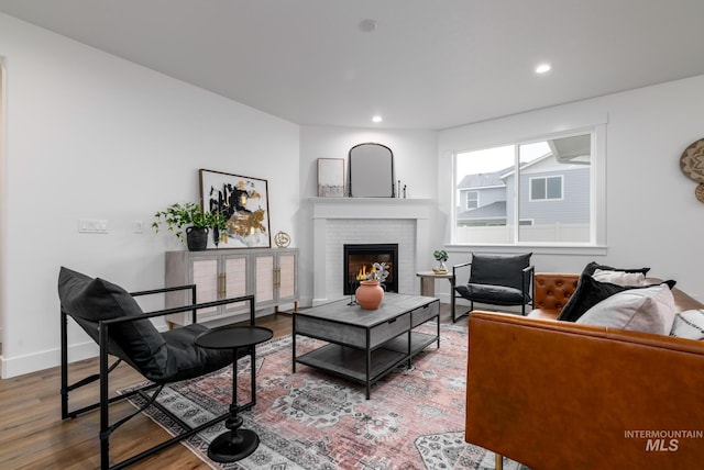 living area with recessed lighting, baseboards, wood finished floors, and a fireplace