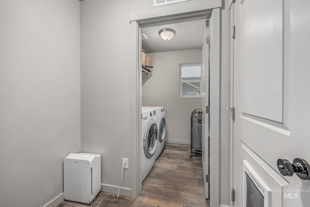 washroom featuring washer and dryer, a textured ceiling, and dark wood-type flooring