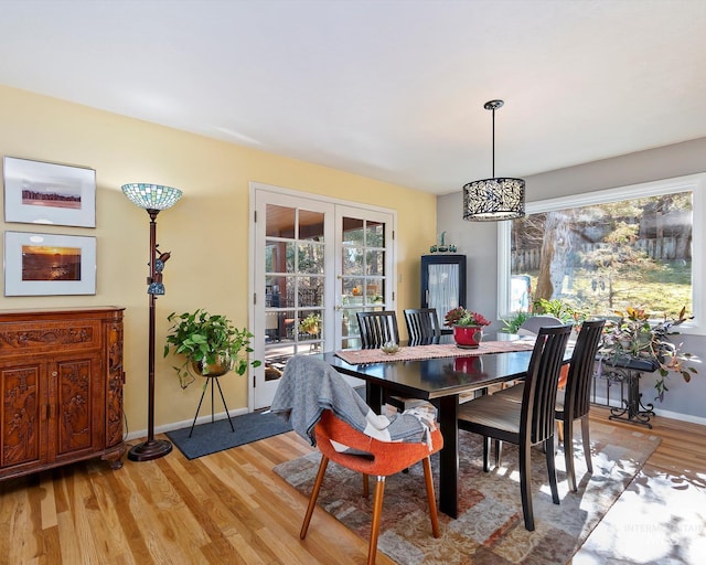 dining space with a healthy amount of sunlight, light wood-style floors, and baseboards