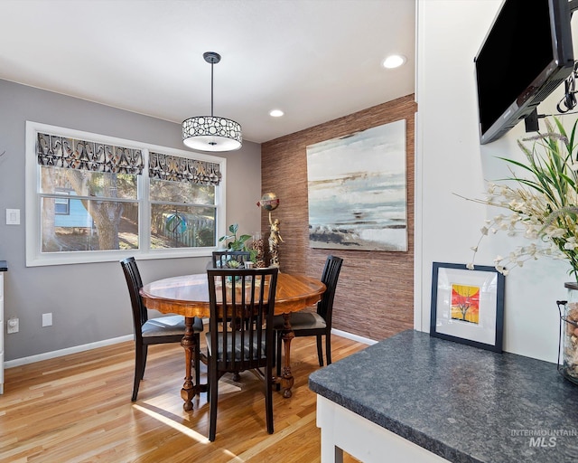 dining space with an accent wall, recessed lighting, light wood-style flooring, and baseboards