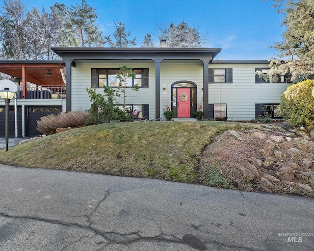 split foyer home featuring a garage and a front yard