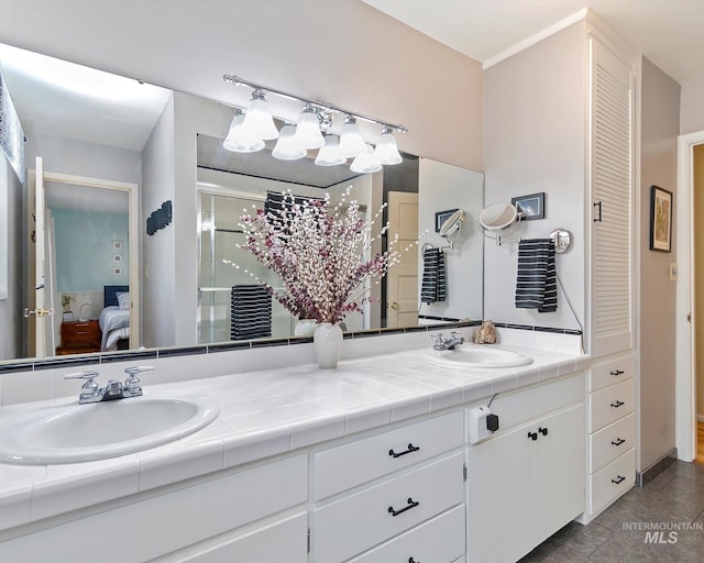 full bath with double vanity, a sink, a shower stall, and ensuite bathroom