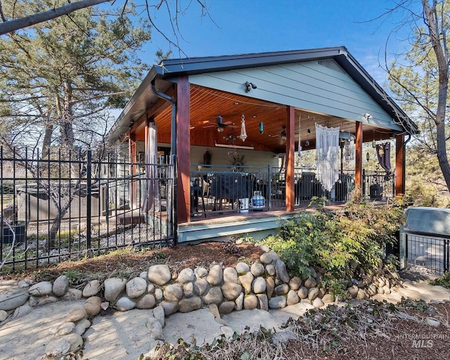 back of house featuring ceiling fan and fence