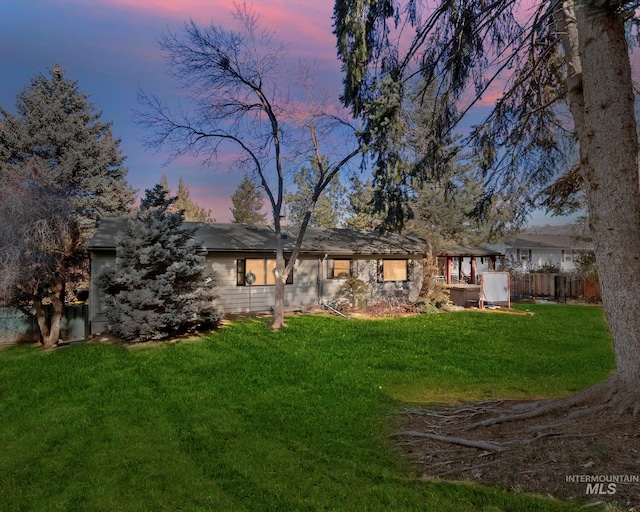 exterior space with fence and a lawn