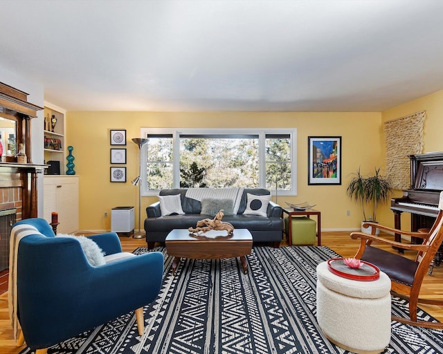 living room featuring a fireplace, wood finished floors, and baseboards