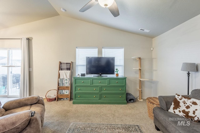 living room featuring a ceiling fan, light carpet, lofted ceiling, and visible vents