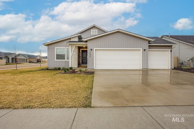 view of front of home featuring driveway, a front yard, a garage, and board and batten siding
