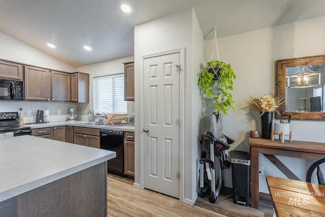 kitchen featuring light countertops, light wood-style flooring, recessed lighting, lofted ceiling, and black appliances