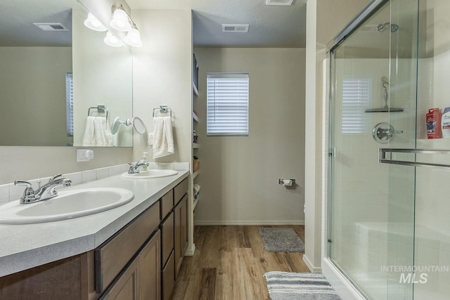 bathroom with visible vents, a sink, and a stall shower