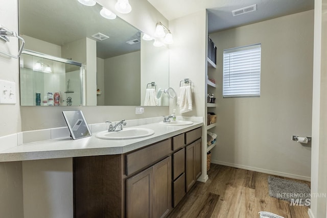 full bathroom featuring visible vents, wood finished floors, and a sink
