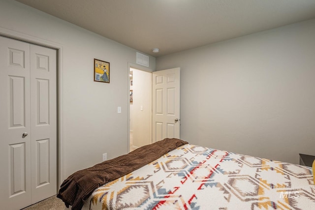 carpeted bedroom featuring visible vents and a closet