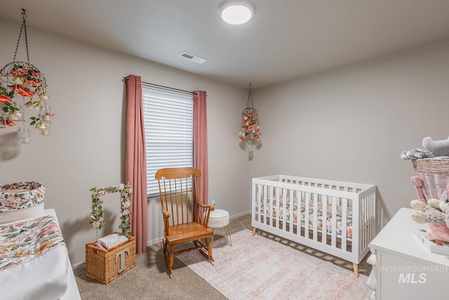 bedroom featuring light carpet, baseboards, a nursery area, and visible vents