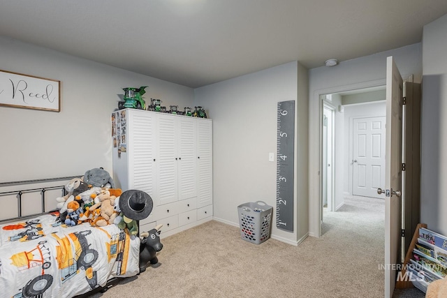 carpeted bedroom featuring baseboards and a closet