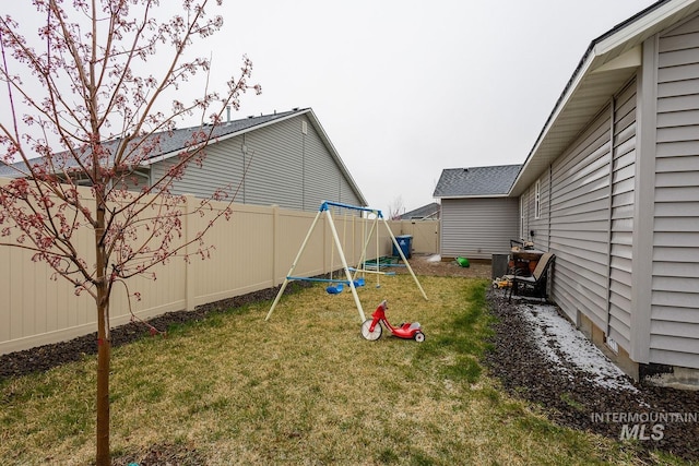 view of yard featuring a fenced backyard and a playground