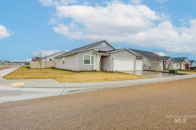 view of front of home featuring a front lawn, a residential view, a garage, and concrete driveway