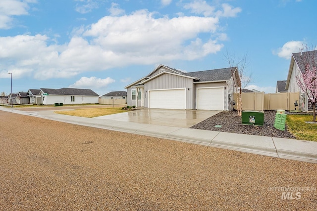 view of front facade featuring fence, a garage, concrete driveway, a front yard, and a residential view