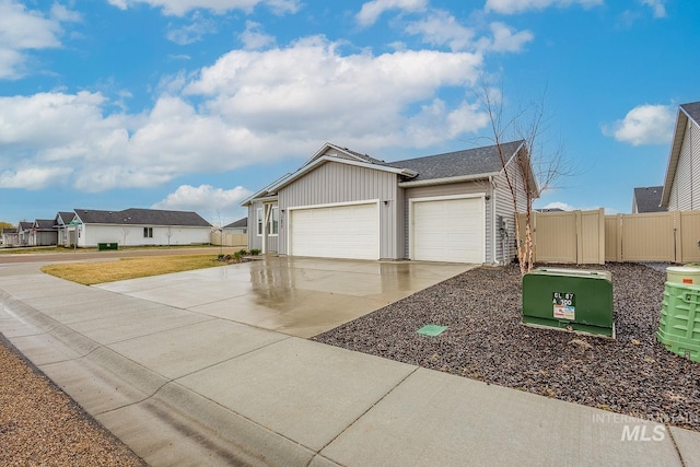 view of front of property featuring fence, a residential view, driveway, a gate, and a garage