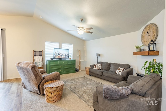 living area featuring lofted ceiling, wood finished floors, and a ceiling fan