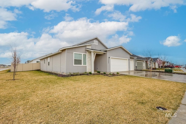 view of front of property featuring driveway, a front yard, fence, an attached garage, and board and batten siding