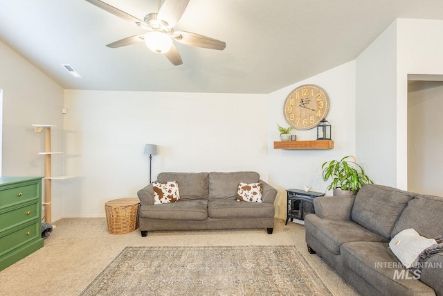 carpeted living area with vaulted ceiling, visible vents, and ceiling fan