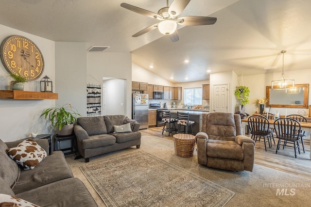 living room featuring lofted ceiling, a textured ceiling, visible vents, and a ceiling fan
