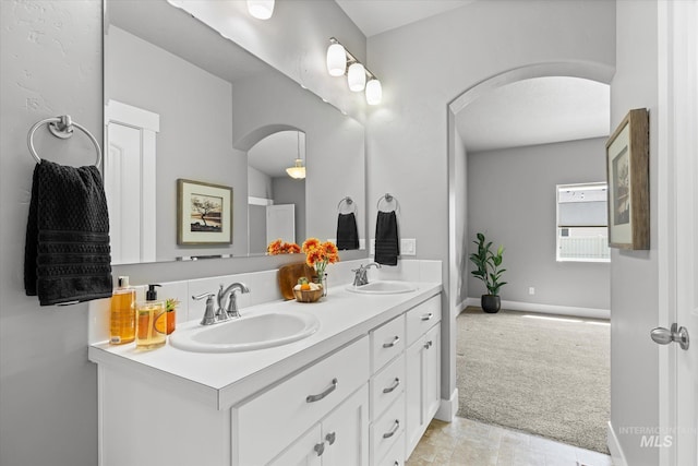 full bathroom with double vanity and baseboards