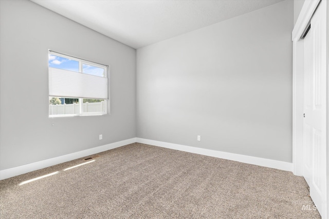 spare room with carpet and baseboards