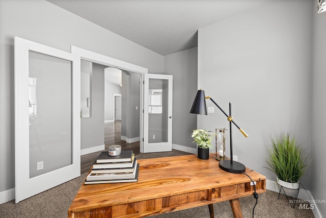 office with arched walkways, baseboards, and carpet flooring