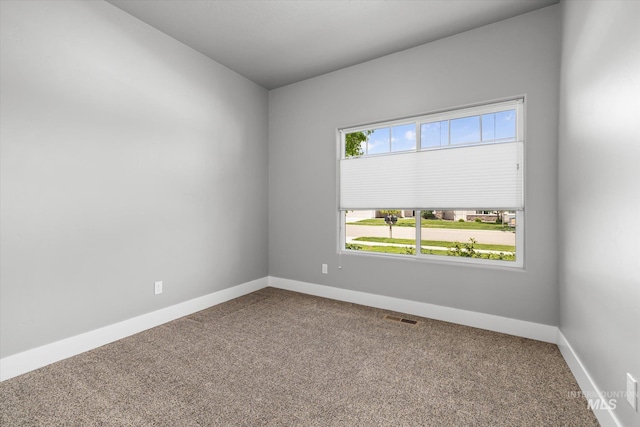 spare room featuring carpet floors and baseboards