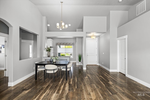 dining room featuring high vaulted ceiling, dark wood-style flooring, a chandelier, and baseboards