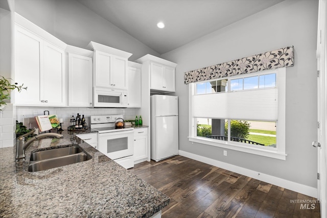 kitchen featuring white appliances, a sink, decorative backsplash, dark stone counters, and white cabinets