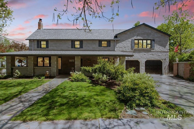 view of front of home featuring a garage and a lawn