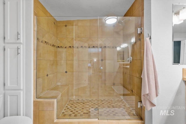 bathroom featuring walk in shower and a textured ceiling