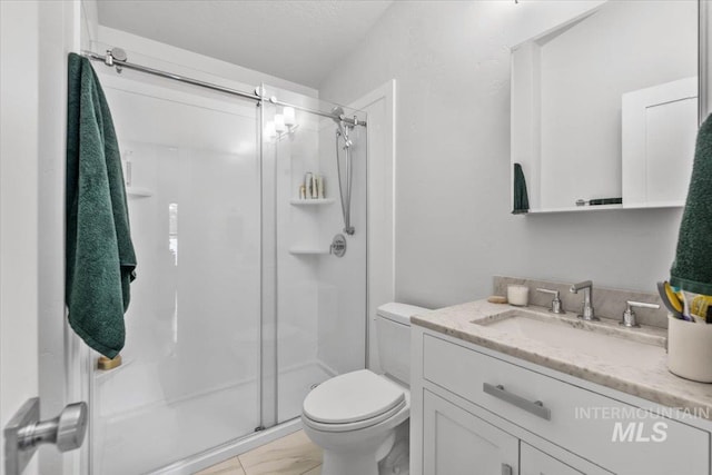 bathroom featuring vanity, toilet, and a shower with shower door